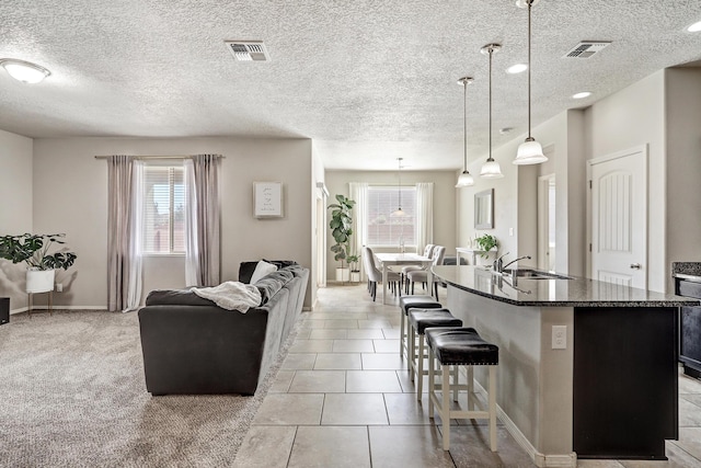 6952 Napoleon Rd NE, Rio Rancho, NM 87144 - kitchen with a sink, plenty of natural light, a breakfast bar, and visible vents