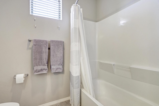 6952 Napoleon Rd NE, Rio Rancho, NM 87144 - bathroom featuring baseboards, shower / bath combo with shower curtain, and toilet
