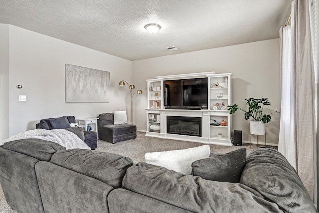 6952 Napoleon Rd NE, Rio Rancho, NM 87144 - carpeted living room featuring a glass covered fireplace, a textured ceiling, and visible vents