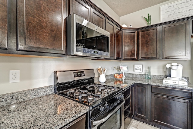 6952 Napoleon Rd NE, Rio Rancho, NM 87144 - kitchen featuring appliances with stainless steel finishes, light stone countertops, a textured ceiling, and dark brown cabinets