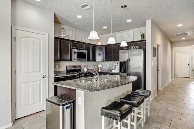 6952 Napoleon Rd NE, Rio Rancho, NM 87144 - kitchen featuring visible vents, a sink, stone counters, and stainless steel appliances