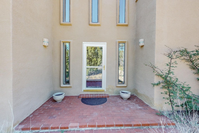 entrance to property featuring stucco siding and a patio area