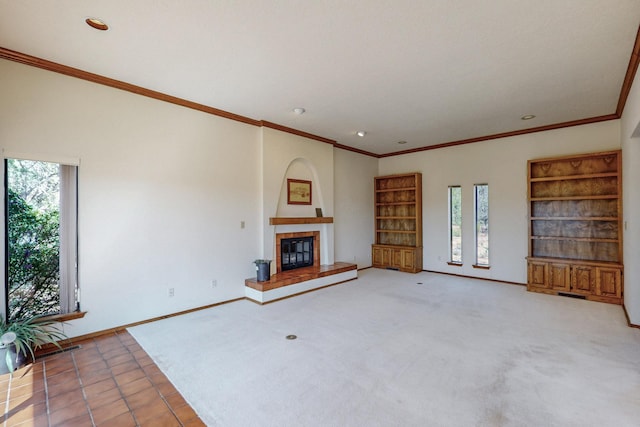 unfurnished living room featuring a tiled fireplace, recessed lighting, and ornamental molding