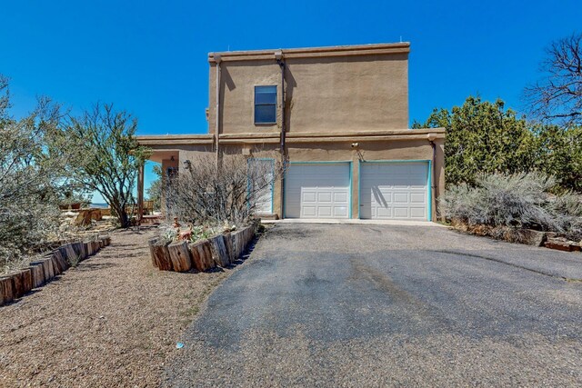view of home's exterior featuring stucco siding, an attached garage, and aphalt driveway