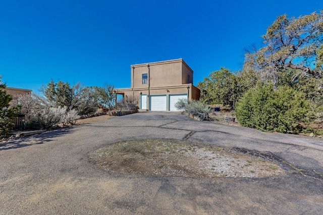 view of front of home featuring driveway, stucco siding, and a garage
