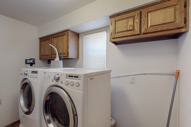 washroom with cabinet space and washing machine and clothes dryer