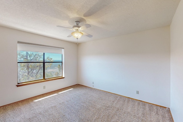 empty room with a ceiling fan, carpet floors, and a textured ceiling