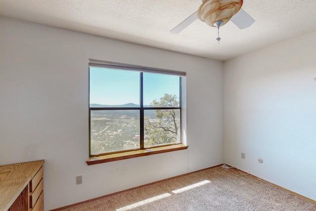 unfurnished room featuring a ceiling fan and carpet floors