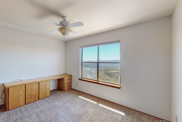 interior space featuring a textured ceiling, ceiling fan, and light carpet