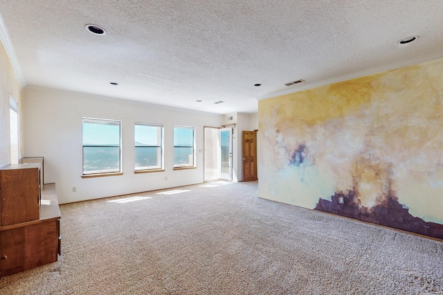 unfurnished room featuring visible vents, ornamental molding, a textured ceiling, and carpet flooring