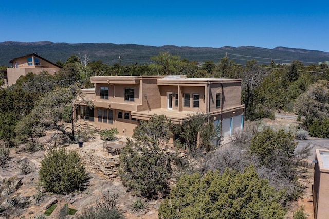 exterior space featuring a mountain view, stucco siding, and a balcony