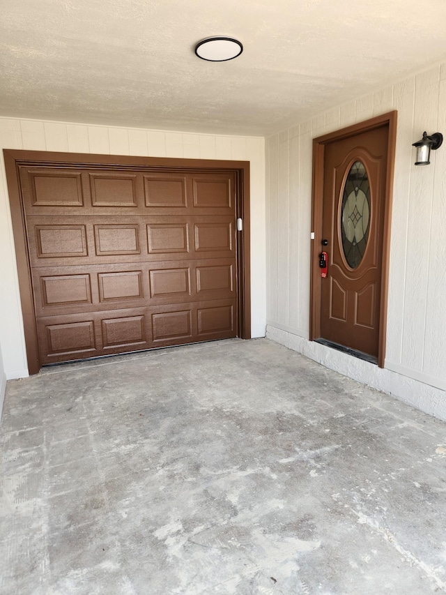 doorway to property with concrete driveway and a garage