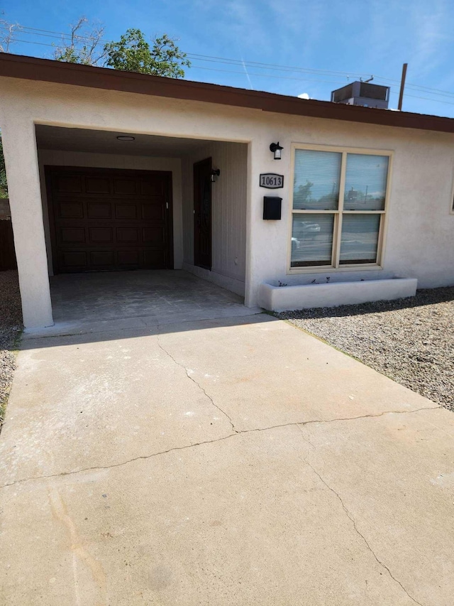 view of front of property with an attached garage, stucco siding, and driveway