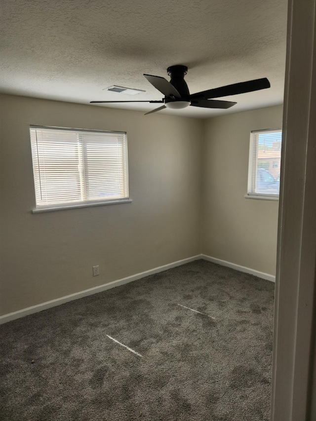 carpeted empty room with a ceiling fan, a textured ceiling, and baseboards