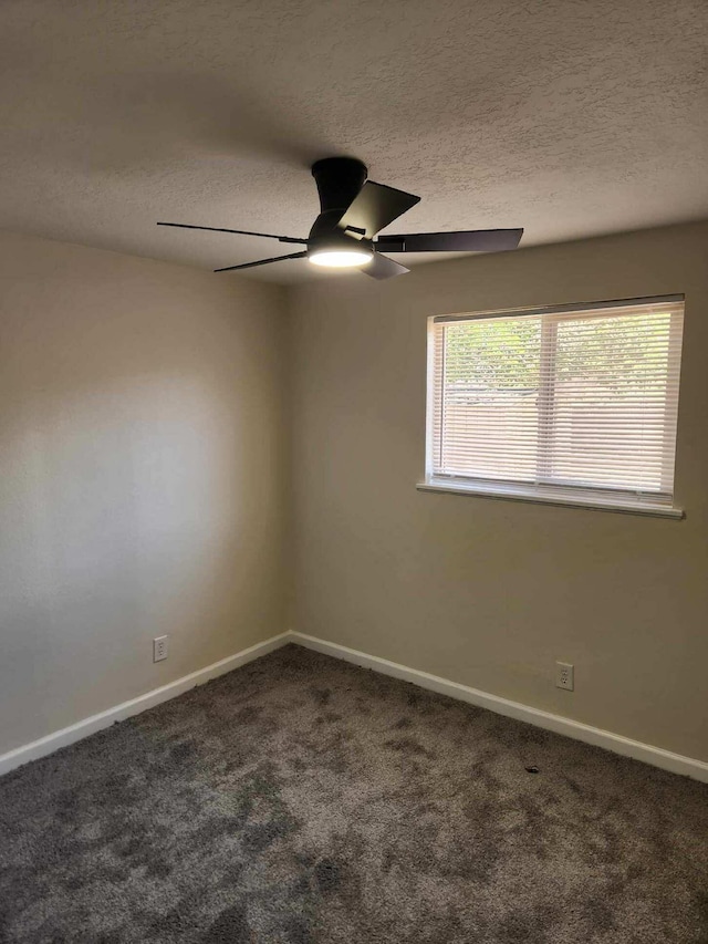 carpeted spare room with baseboards, ceiling fan, and a textured ceiling