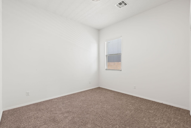 carpeted empty room featuring visible vents and baseboards