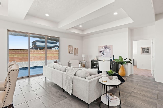 living room featuring recessed lighting, a raised ceiling, and tile patterned floors