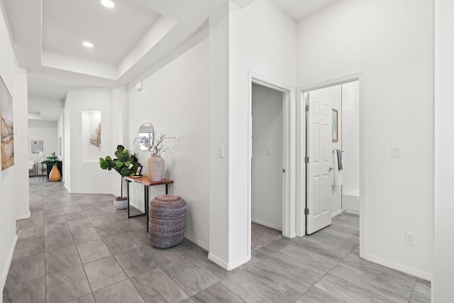 hall with recessed lighting and baseboards