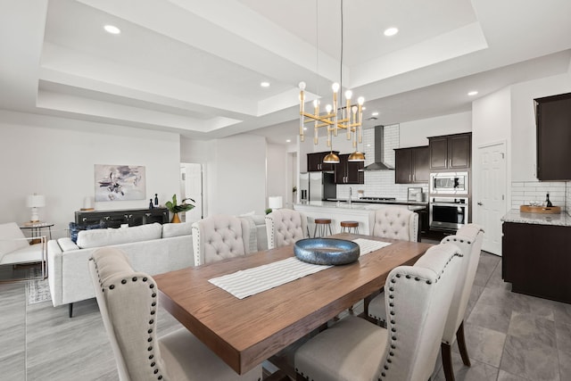 dining room with recessed lighting, an inviting chandelier, and a raised ceiling