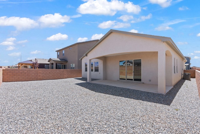 back of property with a patio, cooling unit, a fenced backyard, and stucco siding