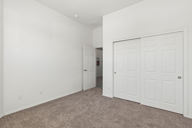 unfurnished bedroom with carpet floors, baseboards, and a closet