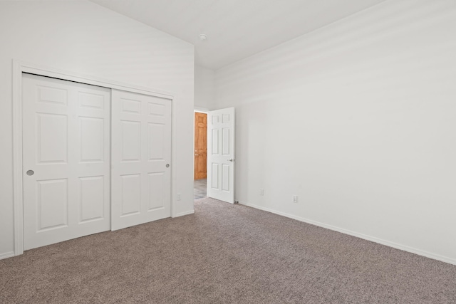 unfurnished bedroom with baseboards, carpet, and a closet