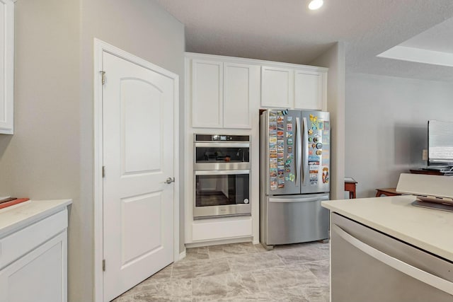 4017 Windy Rd NE, Rio Rancho, NM 87144 - kitchen with white cabinetry, recessed lighting, appliances with stainless steel finishes, and light countertops