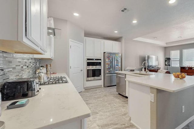 4017 Windy Rd NE, Rio Rancho, NM 87144 - kitchen with a sink, stainless steel appliances, backsplash, light countertops, and an island with sink