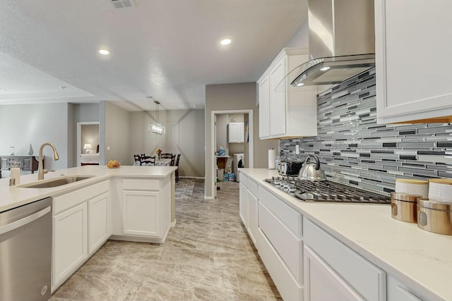 4017 Windy Rd NE, Rio Rancho, NM 87144 - kitchen featuring appliances with stainless steel finishes, light countertops, wall chimney range hood, backsplash, and a sink