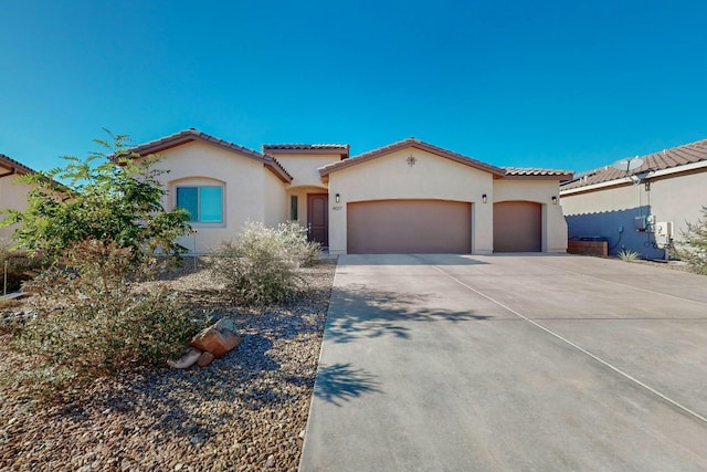 4017 Windy Rd NE, Rio Rancho, NM 87144 - mediterranean / spanish-style home with concrete driveway, an attached garage, a tiled roof, and stucco siding