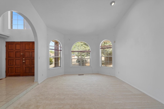 8200 Corona Ave NE, Albuquerque, NM 87122 - entryway with a high ceiling, arched walkways, carpet flooring, and baseboards