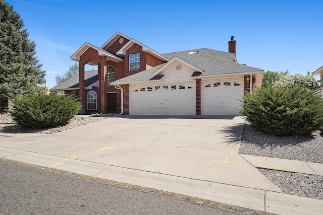 8200 Corona Ave NE, Albuquerque, NM 87122 - traditional-style home with brick siding, driveway, a chimney, roof with shingles, and an attached garage