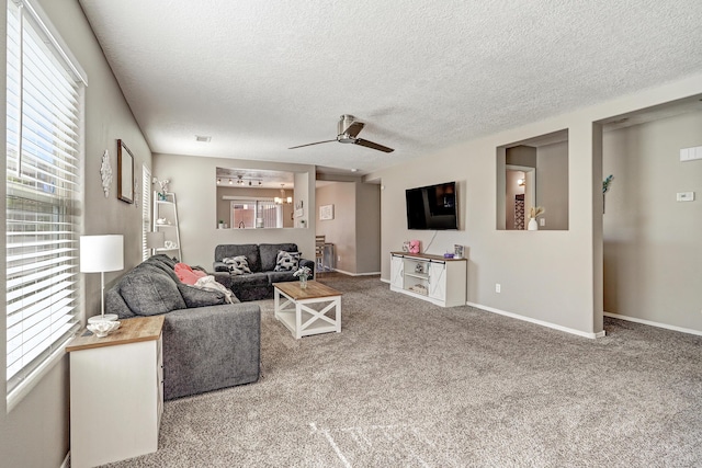 carpeted living area featuring baseboards, ceiling fan, and a textured ceiling
