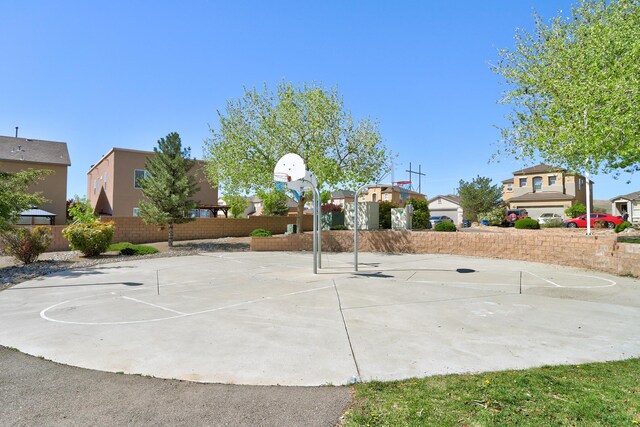 view of basketball court with fence, community basketball court, and a residential view