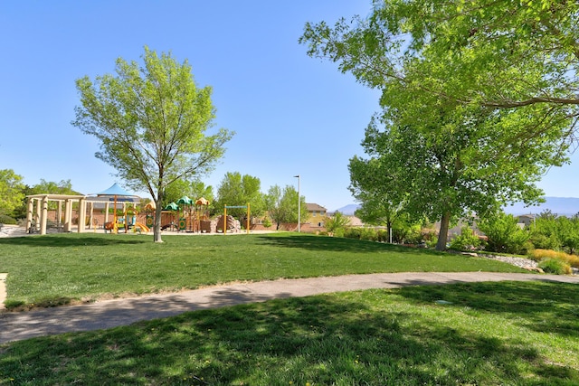 view of property's community with playground community and a yard