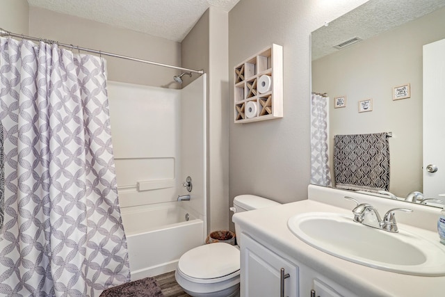 bathroom with a textured ceiling, visible vents, toilet, and vanity