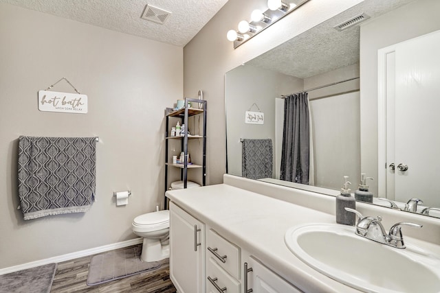 bathroom with visible vents, wood finished floors, a textured ceiling, and vanity