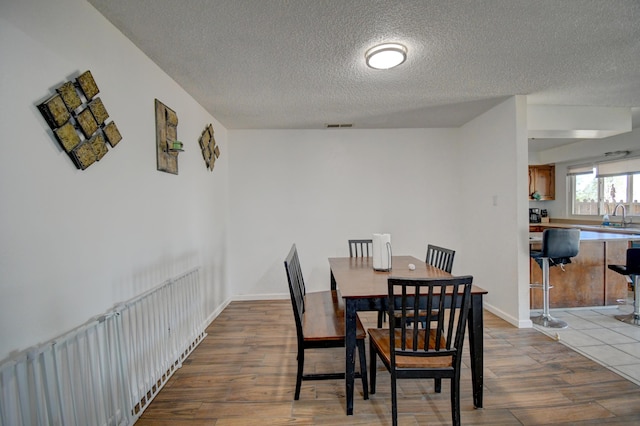 360 Knox Ct, Rio Communities, NM 87002 - dining area with visible vents, a textured ceiling, and wood finished floors