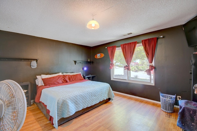 360 Knox Ct, Rio Communities, NM 87002 - bedroom featuring visible vents, baseboards, a textured ceiling, and wood finished floors