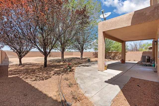 view of yard with a fenced backyard, cooling unit, and a patio area
