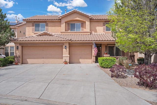 mediterranean / spanish-style house featuring stucco siding, driveway, and a tiled roof