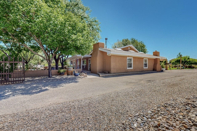 38 Elias Rd, Los Lunas, NM 87031 - view of front of house with stucco siding and a chimney