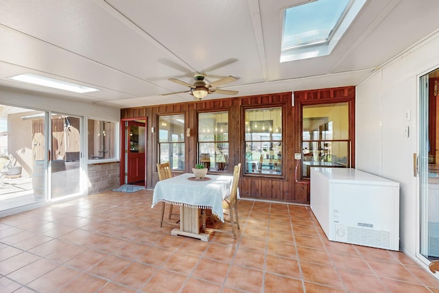 38 Elias Rd, Los Lunas, NM 87031 - dining space featuring a skylight, a ceiling fan, tile patterned flooring, and wood walls