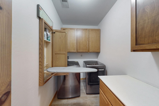 630 Barnett Rd, Bosque Farms, NM 87068 - clothes washing area with cabinet space, washer and dryer, baseboards, and light wood-type flooring