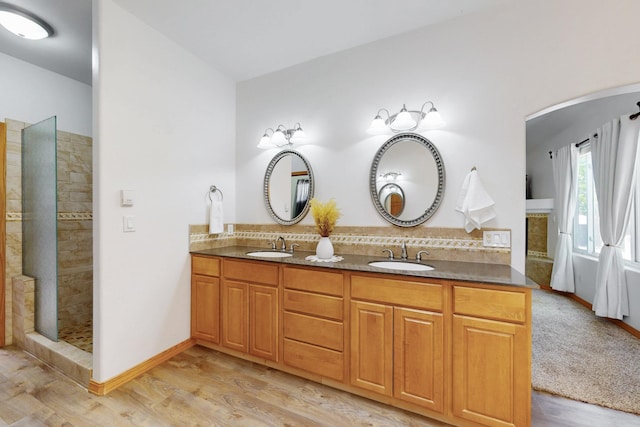 630 Barnett Rd, Bosque Farms, NM 87068 - full bathroom with wood finished floors, decorative backsplash, tiled shower, and double vanity