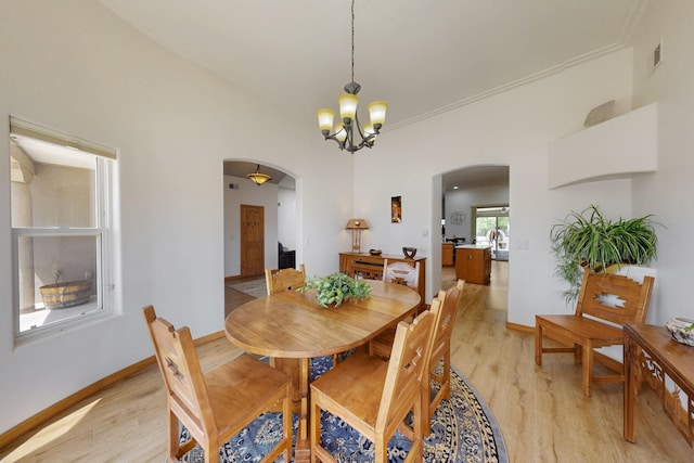 630 Barnett Rd, Bosque Farms, NM 87068 - dining area with arched walkways, light wood-type flooring, a chandelier, baseboards, and ornamental molding