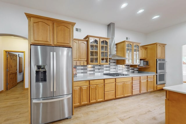 630 Barnett Rd, Bosque Farms, NM 87068 - kitchen with stainless steel appliances, wall chimney exhaust hood, light wood-style floors, arched walkways, and recessed lighting