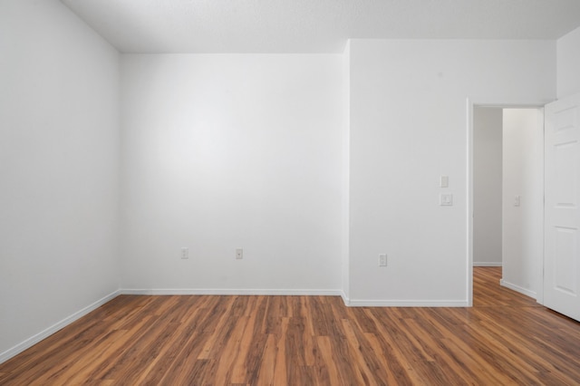 spare room featuring wood finished floors and baseboards