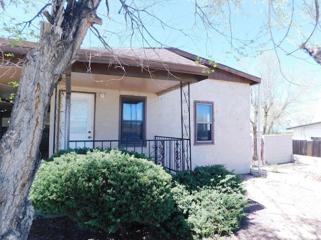 exterior space featuring stucco siding and fence