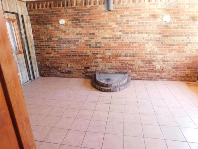 unfurnished dining area with light tile patterned floors and brick wall